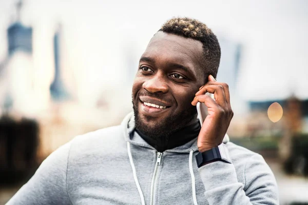 Fekete férfi futó okostelefon a városban, a hívást. — Stock Fotó