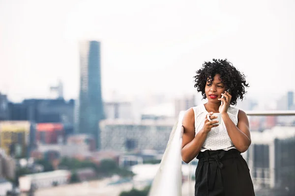 Una mujer de negocios de pie contra el panorama de Londres, haciendo una llamada telefónica . — Foto de Stock