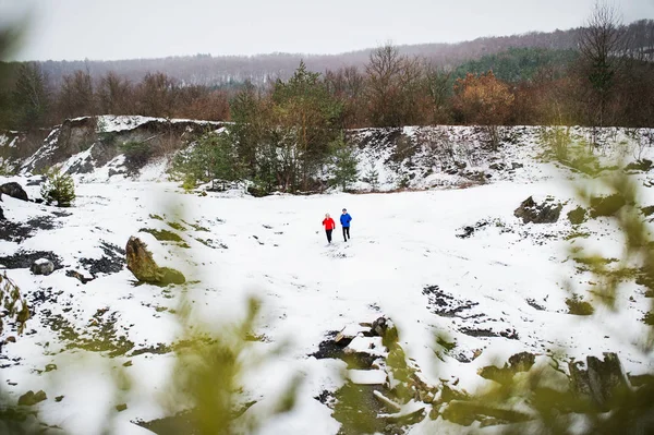 Una coppia anziana che fa jogging nella natura invernale innevata . — Foto Stock
