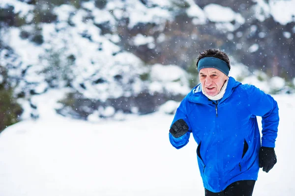 Senior man joggen in de winter natuur. Kopiëren van ruimte. — Stockfoto