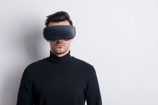 Portrait of a young man with virtual reality goggles in a studio. — Stock Photo, Image