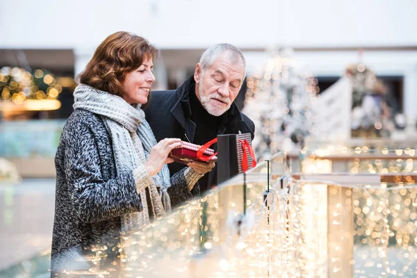 Feliz casal sênior fazendo compras de Natal juntos . — Fotografia de Stock