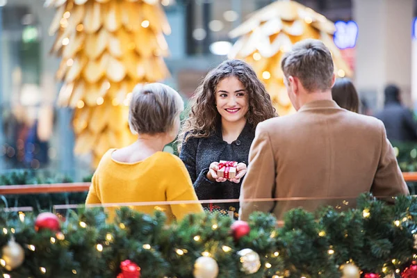 Grootmoeder en tiener kleinkinderen in shopping center op Kerstmis. — Stockfoto