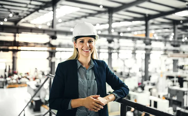 Ένα πορτρέτο του μηχανικός βιομηχανικής γυναίκα στέκεται σε ένα εργοστάσιο. — Φωτογραφία Αρχείου