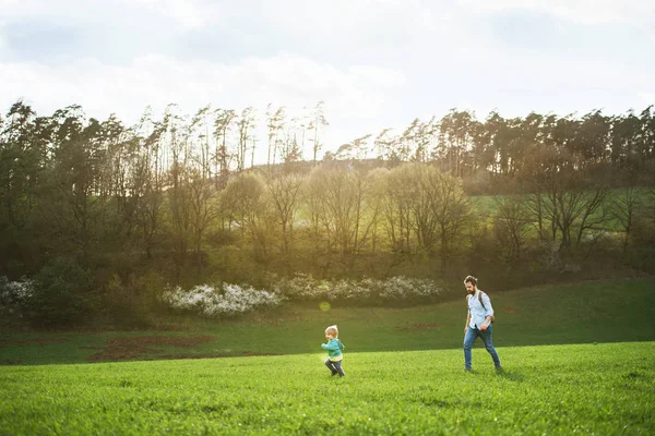 En far med sonen småbarn på en promenad utanför i vår natur. — Stockfoto