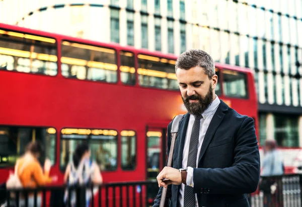 Hipster επιχειρηματίας περιμένοντας το λεωφορείο στο Λονδίνο, τον έλεγχο του χρόνου. — Φωτογραφία Αρχείου