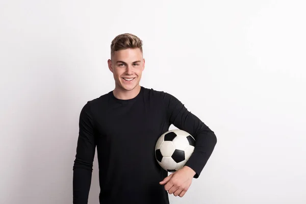 Porträt eines jungen Mannes mit Fußballball in einem Studio. Kopierraum. — Stockfoto