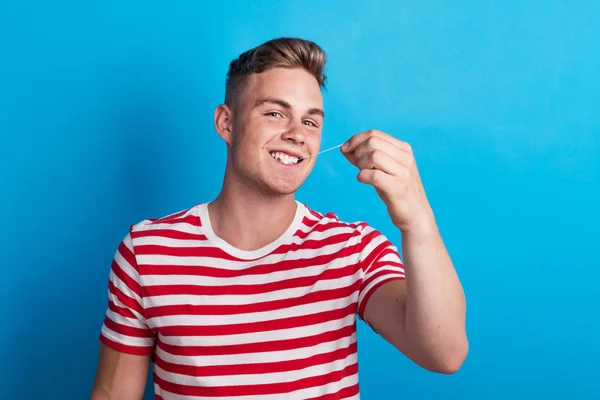 Portret van een jonge man in een studio, trekken uit een kauwgom. — Stockfoto
