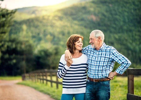 Ett äldre par i love tittar på varandra utomhus i naturen. Kopiera utrymme. — Stockfoto