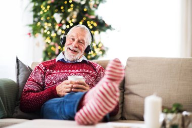 Evde Noel zamanda müzik kulaklık ile üst düzey bir adam.