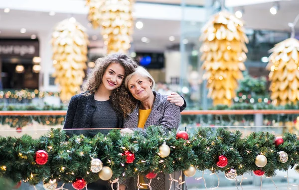 圣诞节期间在购物中心的祖母和十几岁的孙女的画像. — 图库照片