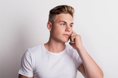 Telefon görüşmesi smartphone bir stüdyoda olan genç bir adam portresi.