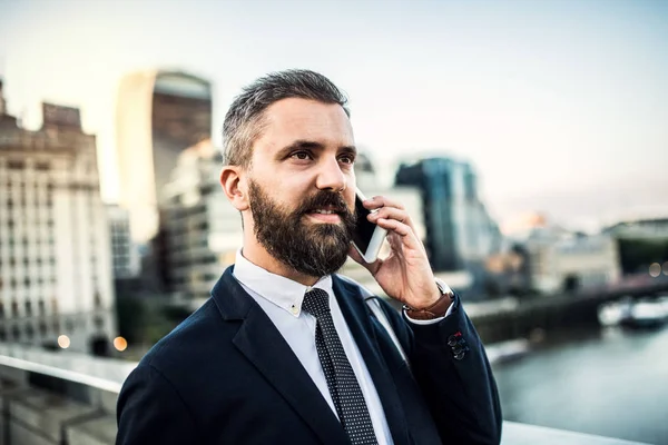 Um close-up de empresário hipster com smartphone na cidade, fazendo um telefonema . — Fotografia de Stock