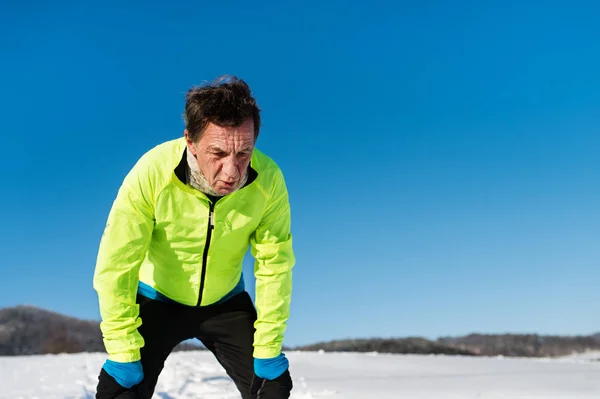 Ett porträtt av äldre man stående efter flykt i vinter natur. — Stockfoto