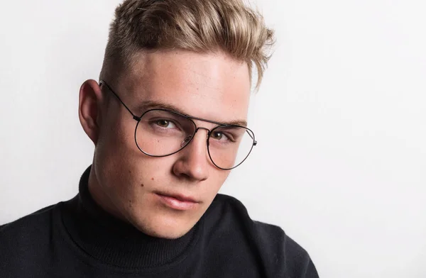 Yakın çekim gözlük takıyor kendine güvenen genç bir adam bir stüdyoda portresi. — Stok fotoğraf