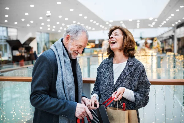 Een Senior Paar Met Papieren Zakken Winkelcentrum Bij Kerstmis Lachen — Stockfoto