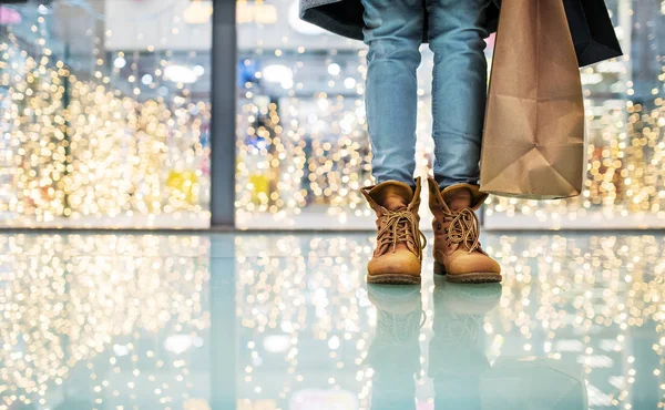Las piernas de una mujer con bolsas en el centro comercial en época de Navidad . —  Fotos de Stock