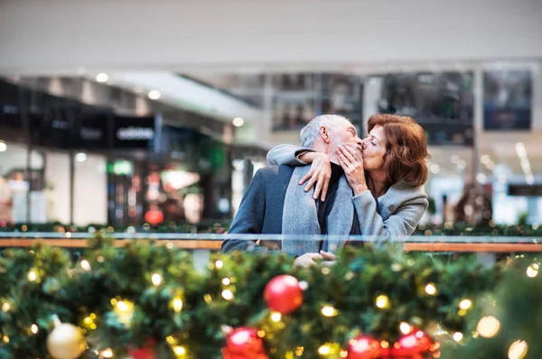 クリスマスの時に、ショッピング センターでシニア カップルのキス. — ストック写真