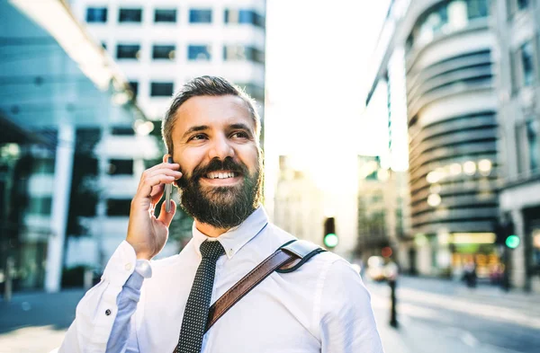Крупним планом хіпстерський бізнесмен зі смартфоном у місті, роблячи телефонний дзвінок . — стокове фото