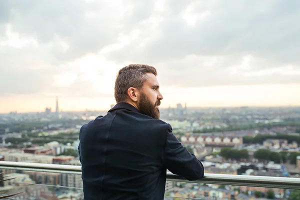 Una vista trasera del hombre de negocios de pie contra el panorama de Londres . —  Fotos de Stock