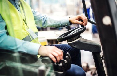 Bir fabrikada forklift oturan tanınmaz endüstriyel adam mühendis.