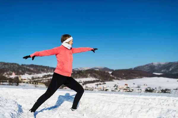 在冬天自然舒展的资深妇女赛跑者。复制空间. — 图库照片