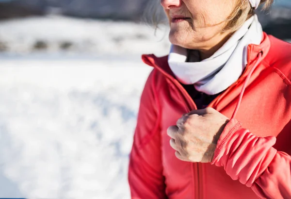 冬の自然で休んで認識できない年配の女性ランナー. — ストック写真