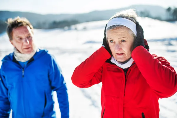 Senioren-Paarläufer stehen in winterlicher Natur und ruhen sich aus. — Stockfoto