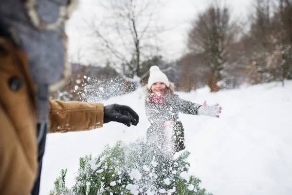 Farfar och liten flicka blir en julgran i skogen. — Stockfoto