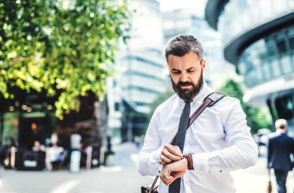 Hipster biznesmen stojąc w London city, sprawdzanie czasu. — Zdjęcie stockowe