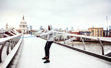Londra'da elastik lastik bantlar ile egzersiz genç aktif siyah sporcu.