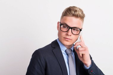 Telefon görüşmesi smartphone bir stüdyoda olan genç bir adam portresi.