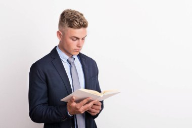 Bir stüdyoda tutarak ve bir kitap okuma genç bir adam portresi.