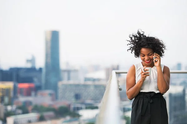 Ritratto di una donna con caffè e smartphone in piedi su una terrazza . — Foto Stock