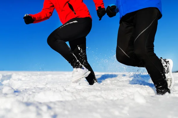Onherkenbaar senior paar joggen in de besneeuwde winter natuur. — Stockfoto