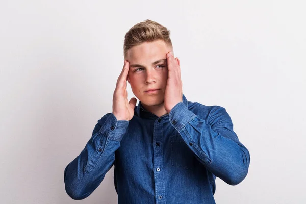 Portrait of a young man in a studio, having headache. — Stock Photo, Image
