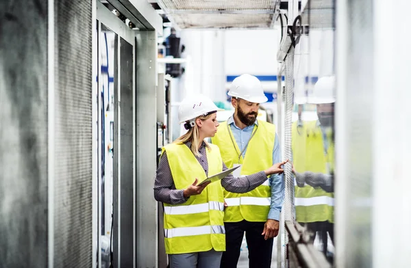 Un portret al unui inginer industrial cu tabletă într-o fabrică, care lucrează . — Fotografie, imagine de stoc