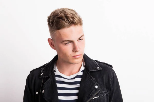 A confident young man in a studio, wearing striped T-shirt. — Stock Photo, Image