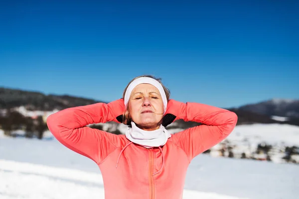 Mujer mayor corredora descansando en invierno naturaleza, ojos cerrados y manos detrás de la cabeza . —  Fotos de Stock