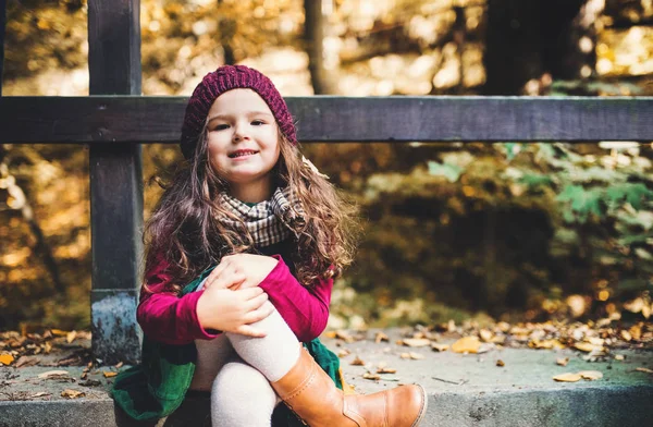 Sonbahar Doğa ormanda oturan bir küçük yürümeye başlayan çocuk kız portresi. — Stok fotoğraf