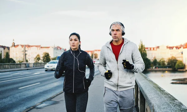 Een geschikt paar met koptelefoon uitgevoerd buiten op de brug in Praag stad. — Stockfoto