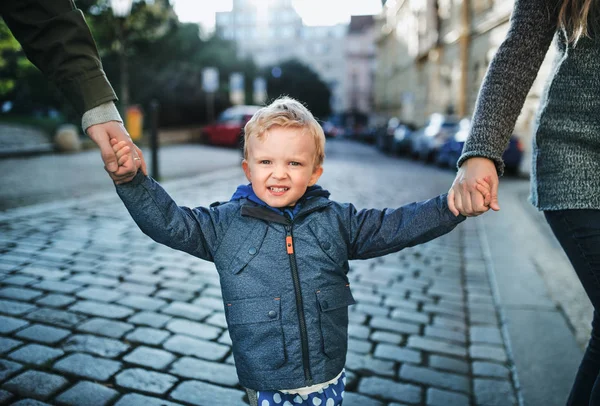 Een kleine peuter jongen met onherkenbaar ouders buiten lopen in de stad. — Stockfoto