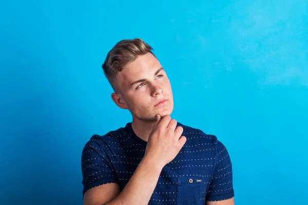 Retrato de un joven serio y considerado en un estudio de pie en un estudio . — Foto de Stock