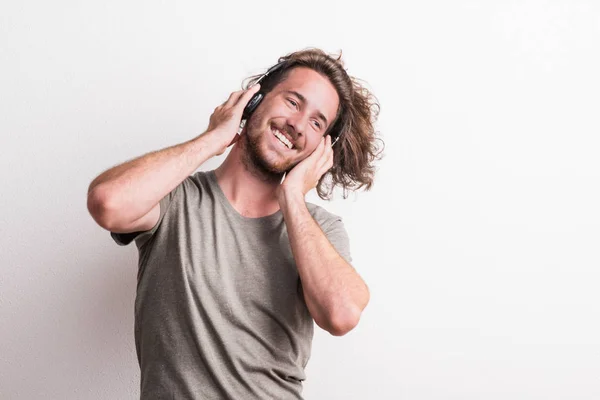 Portrait of a joyful young man with headphones in a studio. — Stock Photo, Image