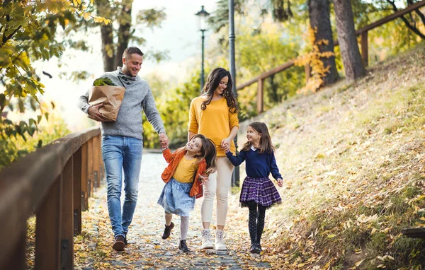 Una familia joven con niños caminando en el parque en otoño . —  Fotos de Stock