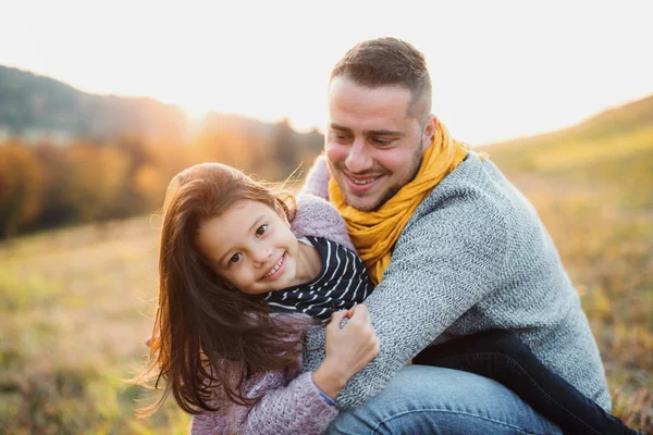 Een jonge vader plezier maken met een kleine dochter in de herfst natuur. — Stockfoto