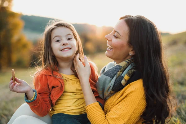 Un portrait de jeune mère avec une petite fille dans la nature d'automne au coucher du soleil. — Photo