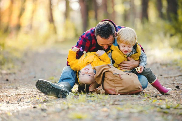 Ein reifer Vater mit Rucksack und Kleinkind im herbstlichen Wald. — Stockfoto
