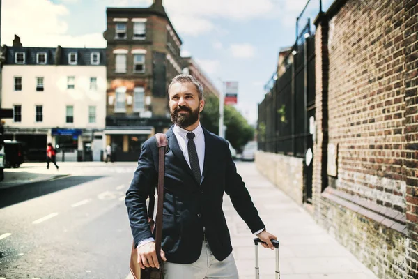 Hipster hombre de negocios con maleta caminando por la calle en Londres . — Foto de Stock
