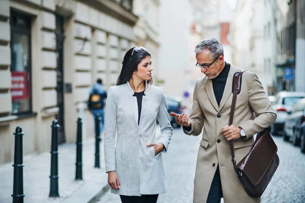 Man and woman business partners walking outdoors in city of Prague, talking. — Stock Photo, Image